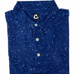 Folded blue polo shirt with white speckles on a white background