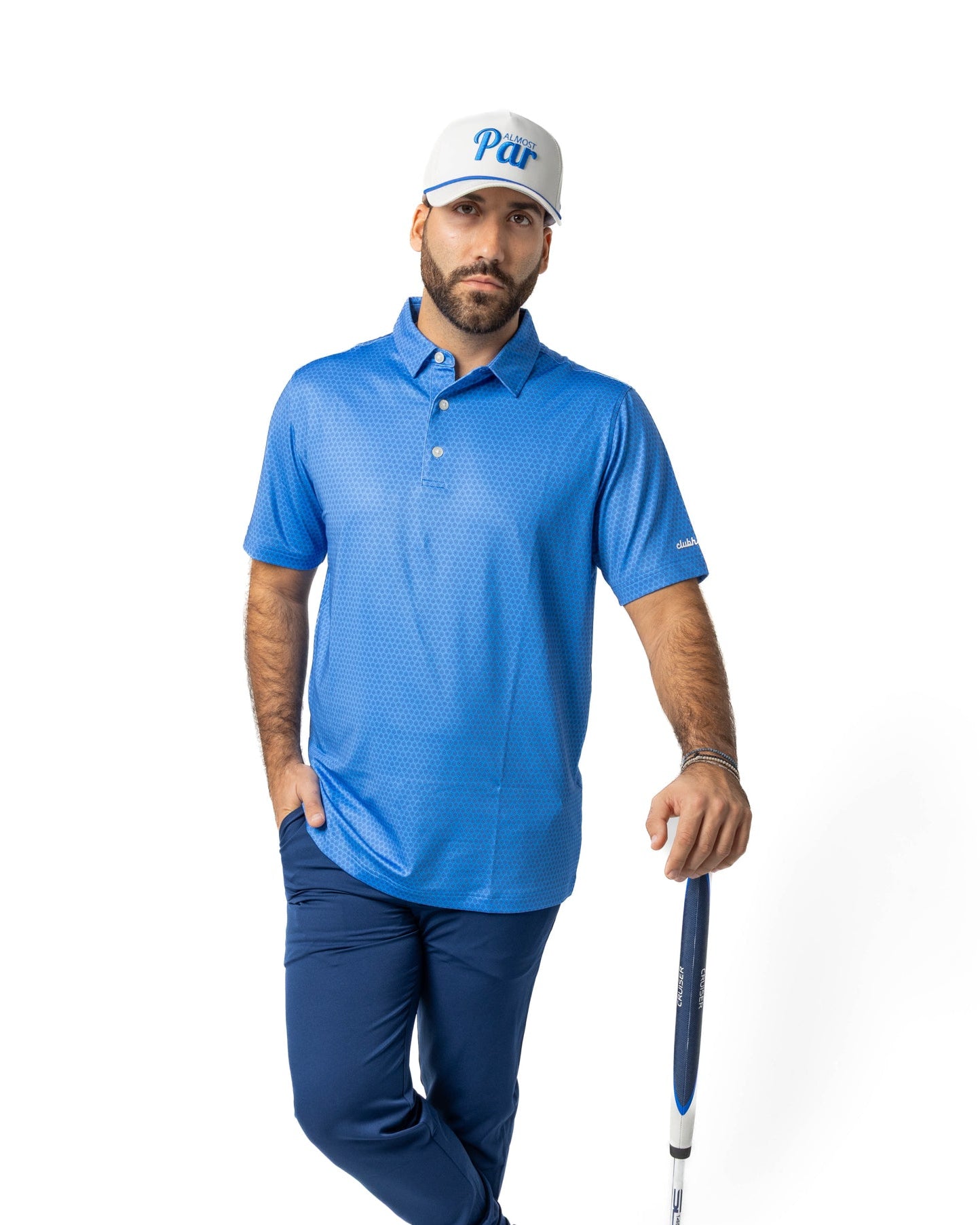 Man in blue golf attire holding a golf club on a white background