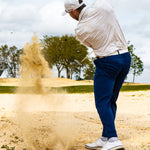 Golfer hitting sand shot in sandstorm polo